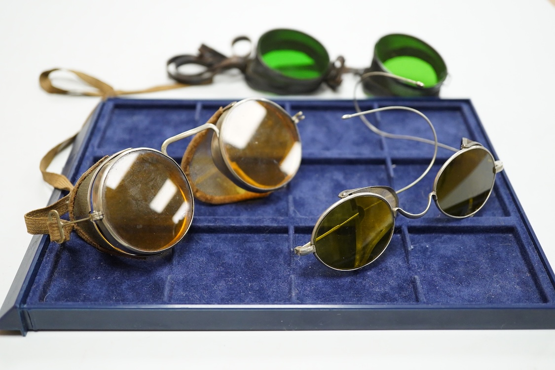 A pair of Wellsworth safety goggles with mesh sides, a pair of green tinted safety goggles with mesh sides, cased, and a pair of mesh wire sided safety spectacles with green tinted lenses (3)